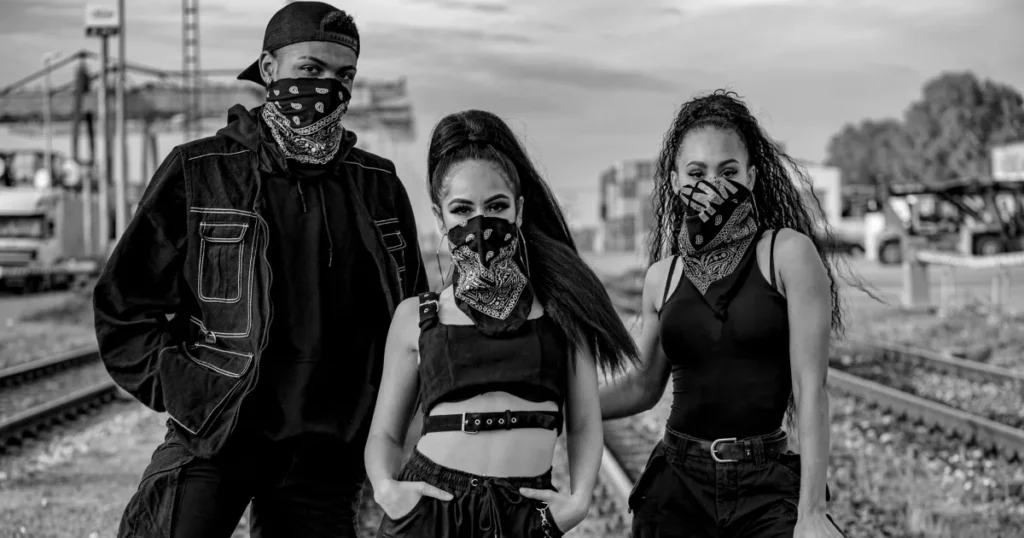 one boy with a mask and two masked girls wearing streetwear standing n the road with a style
